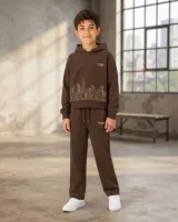 Koyu kahverengi kapüşonlu sweatshirt ve eşofman altından oluşan erkek çocuk eşofman takımı, beyaz spor ayakkabı giymiş 11-14 yaş arası çocuk modeli üzerinde – sentetik çocuk manken ile hero görünümü