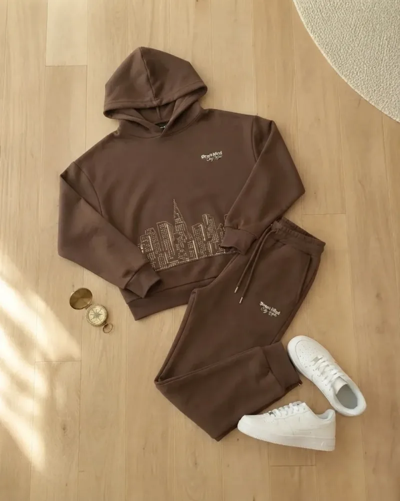 Koyu kahverengi kapüşonlu sweatshirt ve eşofman altı takımı giymiş erkek çocuk – stilist ürün parçaları kompozisyonu